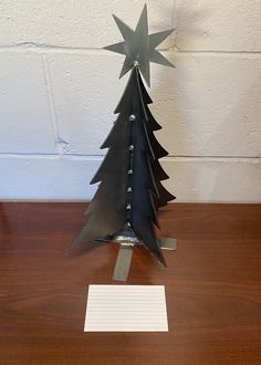 a metal christmas tree sitting on top of a wooden table