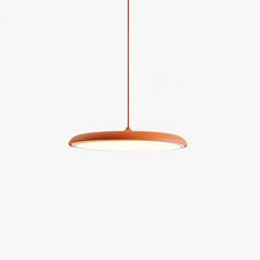 an orange pendant light hanging from a ceiling