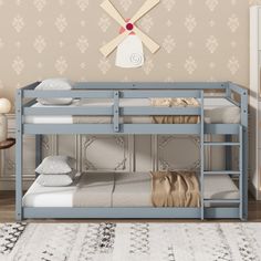 a blue bunk bed sitting next to a wall with a clock on it's face