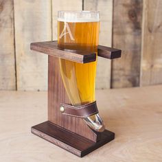 a wooden stand holding two beer glasses on top of each other with the letter a in it