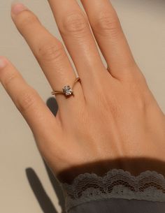 a woman's hand with a diamond ring on top of her finger and lace around the band