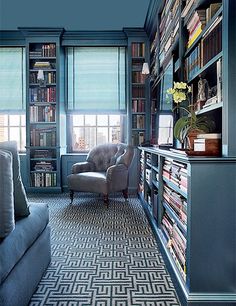 a living room filled with furniture and bookshelves covered in lots of bookcases