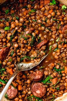 a pot filled with beans, sausage and spinach