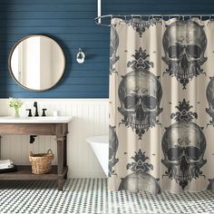 a bathroom with a skull shower curtain next to a bathtub and sink in front of a mirror