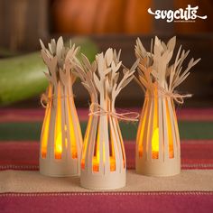 three small vases with candles in them on a table