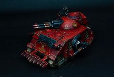 a red painted warhammer tank on a black background