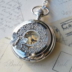 "Bright silver pocket watch inspired by the butterfly effect theory. The watch cover filigree is embellished with a beautiful silver butterfly. Simply press the top notch to reveal the face of the watch. Butterfly Effect Silver Watch Necklace comes gift wrapped ready for gift giving. ♥ ♥ ♥ It has been said that something as small as the flutter of a butterfly's wing can ultimately cause a typhoon halfway around the world. - Chaos Theory ♥ ♥ ♥ ♥ 30\" Silver necklace ♥ Round shape of clock measure Pendant Watch, Silver Pocket Watch, Magical Jewelry, Butterfly Effect, Fantasy Jewelry, Butterfly Pendant, Pretty Jewellery