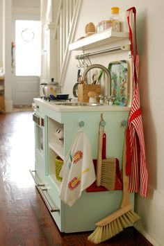 a kitchen area with a sink, stove and broom