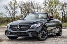 the mercedes c - class cab is parked in front of some trees and dirt road