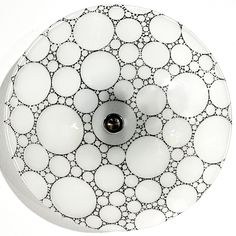 a bathroom sink with white and black circles on the bowl, which is surrounded by bubbles