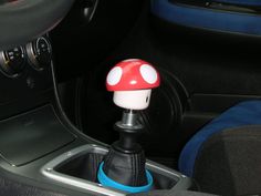 a red and white mushroom sitting on top of a blue cup holder in a car