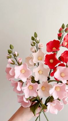 a person's hand holding a bunch of fake flowers