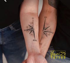 two people with tattoos on their arms holding each other's hands and looking at the same direction