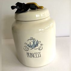 a white ceramic jar with a black bow on the top and princess written on it