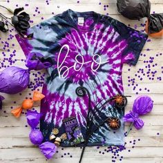 purple and black tie - dye shirt with boo on it, surrounded by halloween decorations