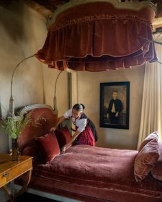 a woman standing in front of a red bed