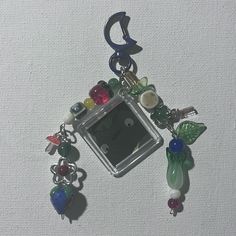 a keychain with charms attached to it on a white tablecloth background,