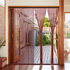 an open door with red curtains and wooden flooring