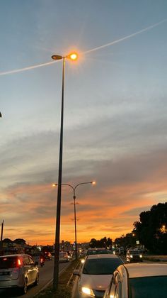 cars are parked on the side of the road at sunset