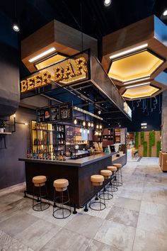 the interior of a bar with stools and lights