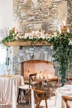 the fireplace is decorated with flowers and candles for an elegant wedding reception in front of a stone fire place