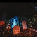 a cemetery with tombstones and headstones lit up at night