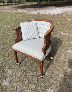 a chair sitting in the middle of a field with grass and trees behind it,