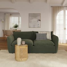 a living room with a large green couch and white rug on top of the floor