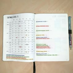 an open notebook with some type of calendar on the page and a pen next to it