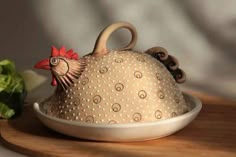 a ceramic chicken sitting on top of a bowl