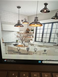 a computer screen showing an image of a kitchen and dining room with lights hanging from the ceiling