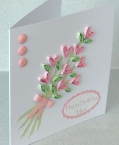 a mother's day card with pink flowers and hearts on the front, sitting on a table