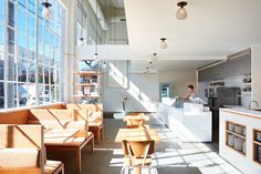 the sun shines through windows in an empty restaurant with wooden benches and counter tops