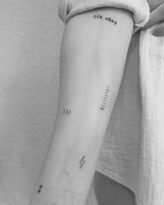 a woman's arm with an arrow and stars tattoo on the left side of her arm