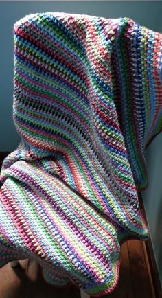 a crocheted blanket sitting on top of a wooden chair