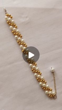 a gold and white beaded bracelet with pearls on the side, next to an earring