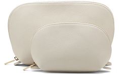 two white purses sitting next to each other on a white surface with no one around them