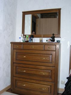 a wooden dresser with a mirror on top of it