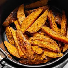 cooked sweet potato wedges in an air frying pan, ready to be eaten