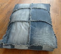 a cushion made out of jeans sitting on top of a wooden floor