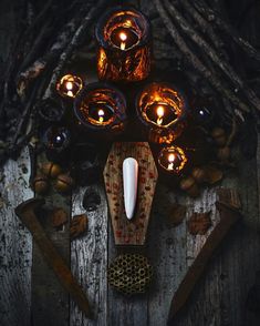 a group of candles sitting on top of a wooden table next to an animal mask