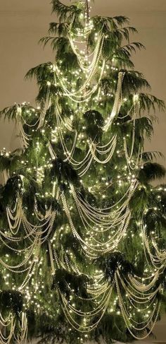 a christmas tree is decorated with lights and garlands in the shape of trees,