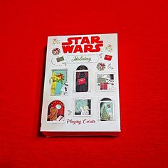 the star wars holiday sticker book is on a red surface