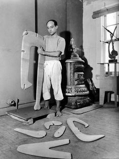 a man standing next to a bunch of surfboards on top of a hard wood floor