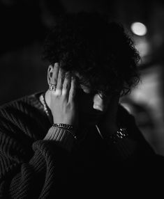 black and white photograph of a woman holding her hand to her face with both hands