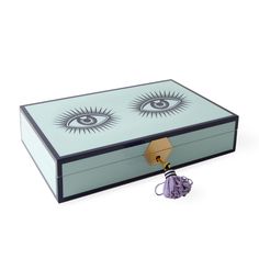 a box with an eye design on it and a tassel hanging from the lid