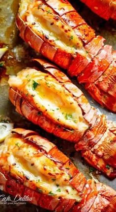 cooked lobsters on a baking sheet with lemon wedges and parsley