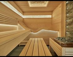 the inside of a sauna with wooden benches and stone walls in front of it