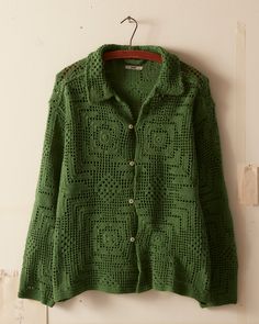 a green jacket hanging up on a wall