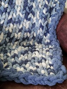 a blue and white blanket sitting on top of a couch